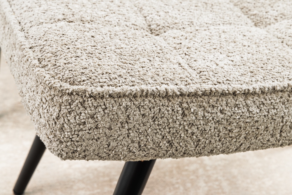 Moderner Hocker SCANDINAVIA champagner greige Bouclé schwarze Metallbeine Fußhocker